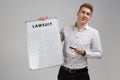 Young man holding a poster with the inscription lawsuit isolated on a light background Royalty Free Stock Photo