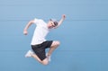 Portrait of a young man in a white T-shirt tv in the air on a blue background Royalty Free Stock Photo