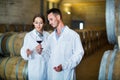 Portrait of young man and woman holding glass of wine in winery Royalty Free Stock Photo