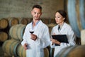 Portrait of young man and woman holding glass of wine in winery Royalty Free Stock Photo