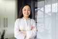 Portrait of young mature asian businesswoman entrepreneur, woman with crossed arms smiling and looking at camera Royalty Free Stock Photo