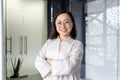 Portrait of young mature asian businesswoman entrepreneur, woman with crossed arms smiling and looking at camera Royalty Free Stock Photo