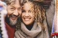 Portrait of young mature couple smiling and enjoying leisure activity together under a colorful knit wool cover. Love and