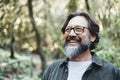 Portrait of young mature man alone smiling outside with nature trees in background. Environment. Happy people enjoying outdoor Royalty Free Stock Photo