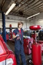 Portrait of a young mechanic standing by welding equipment