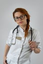 Portrait of young medical doctor in white uniform and stethoscope on grey background Royalty Free Stock Photo