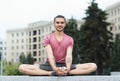 Portrait of young men doing butterfly yoga pose outdoors