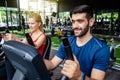 Portrait of young man exercising using stationery bike in gym with a group of people. Fitness class doing sport biking in the gym Royalty Free Stock Photo