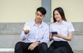 Portrait of young man and girl in university uniform sitting and hold a small house and calculator, Concept of sustaining a house