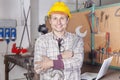 Portrait of young metalworker arms folded with wrench