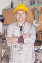 Portrait of young metalworker arms folded with wrench