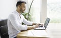 Portrait young mexican attractive businessman working at modern home office with computer laptop Royalty Free Stock Photo