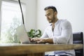 Portrait young mexican attractive businessman working at modern home office with computer laptop Royalty Free Stock Photo