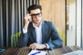 Portrait of young minded man thinking about task in office