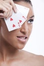 Portrait of young Mixed Race woman covering her eye with playing card against white background Royalty Free Stock Photo