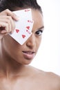 Portrait of young Mixed Race woman covering her eye with playing card against white background Royalty Free Stock Photo