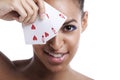 Portrait of young Mixed Race woman with playing cards biting her lip against white background Royalty Free Stock Photo