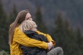 Portrait of young mom and son outside. Mother hugs her child son sitting on halt in woods. Happy family.Hike in the fall Royalty Free Stock Photo