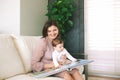 Portrait of young mother and adorable baby watching family album together