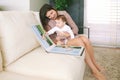 Portrait of young mother and adorable baby watching family album together