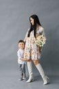 Portrait of a young mother with a bouquet of white tulips and a young son having fun. Family, charming child, the concept of love Royalty Free Stock Photo