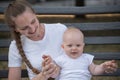 Portrait of young mother and cute baby in white clothes. Joys of motherhood Royalty Free Stock Photo