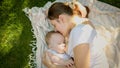 Portrait of young mother feeding her little baby son with breast milk on grass at park Royalty Free Stock Photo