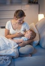 Portrait of young mother giving bottle with milk to her baby in Royalty Free Stock Photo