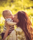 Portrait of young mother and her baby boy, time for kisses. Royalty Free Stock Photo