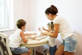 Portrait of a young mother with her little daughter and son sculpt a dough on a kitchen Royalty Free Stock Photo