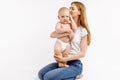 Loving mom hugs and kisses her baby on isolated white background Royalty Free Stock Photo