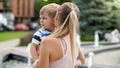 Closeup portrait of young mother hugging and caressing her crying little child boy in park Royalty Free Stock Photo