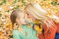 Portrait of young mother playing with her daughter in autumn park Royalty Free Stock Photo