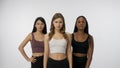 Portrait of young multiethnic models on white studio background close up. Group of three appealing multiracial girls Royalty Free Stock Photo