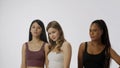 Portrait of young multiethnic models on white studio background close up. Group of three appealing multiracial girls Royalty Free Stock Photo