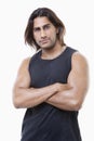 Portrait of young muscular man with arms crossed standing over white background Royalty Free Stock Photo