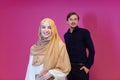 Portrait of young muslim couple isolated on pink background