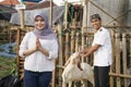 Muslim woman with goat for idul adha qurban sacrifice