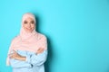 Portrait of young Muslim woman in hijab against color background. Royalty Free Stock Photo