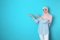 Portrait of young Muslim woman in hijab against color background. Royalty Free Stock Photo