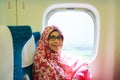 Portrait of young muslim woman sitting by window inside Japanese bullet train Royalty Free Stock Photo