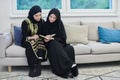 Portrait of young muslim women reading Quran in modern home.