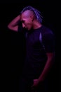 Portrait of a young naked african man at studio. High Fashion male model in colorful neon bright lights posing on black background Royalty Free Stock Photo