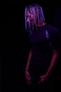 Portrait of a young naked african man at studio. High Fashion male model in colorful neon bright lights posing on black background Royalty Free Stock Photo