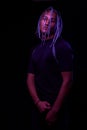 Portrait of a young naked african man at studio. High Fashion male model in colorful neon bright lights posing on black background Royalty Free Stock Photo