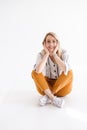 Portrait of young nice woman wearing glasses smiling at camera and sitting on the floor with legs crossed Royalty Free Stock Photo