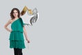 Portrait of young nice woman wearing green summer dress holding balloon stars against grey studio wall banner background Royalty Free Stock Photo