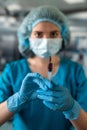 nurse in mask and gloves holding a syringe with medicine and waiting for a patient in surgery. Royalty Free Stock Photo