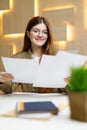 Portrait of a young office staff woman with paper in her hands at the workplace, reports and financial mail Royalty Free Stock Photo