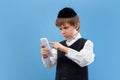 Portrait of a young orthodox jewish boy isolated on blue studio background, meeting the Passover Royalty Free Stock Photo